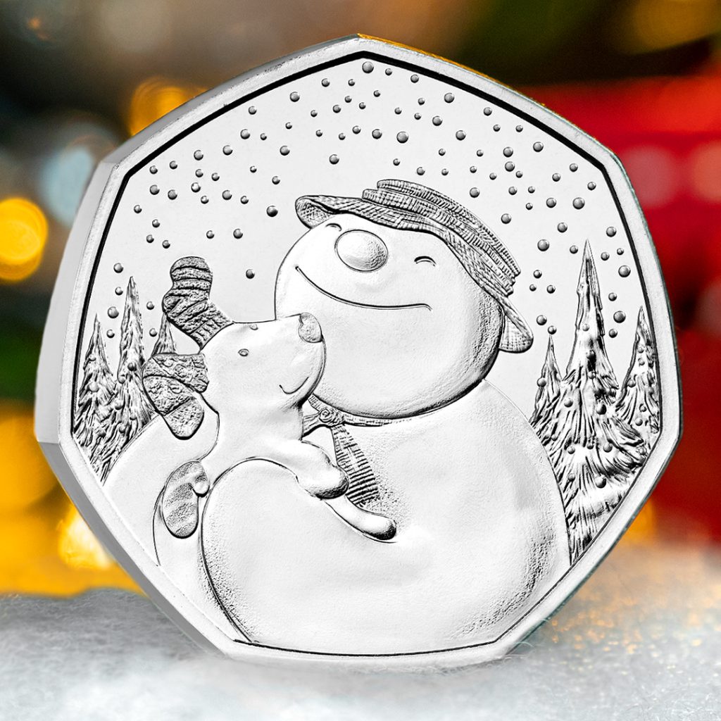 The  UK Snowman and The Snowdog 50p reverse showing both characters embracing, with snowfall and alpine trees behind.